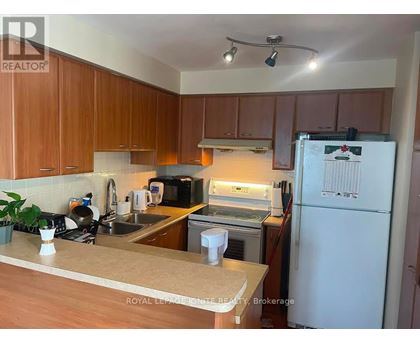 A kitchen with wooden cabinets and a white fridge.