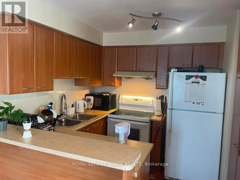 A kitchen with wooden cabinets and a white fridge.