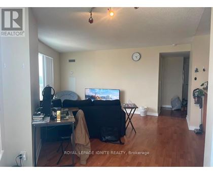 A living room with a couch, a television, and a desk with a computer.