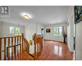 A spacious room with a wooden staircase and white walls.