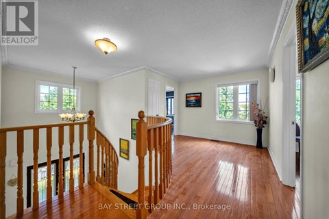 A spacious room with a wooden staircase and white walls.
