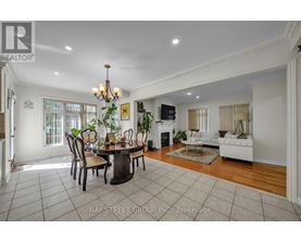 A dining room with a table set for six with a chandelier above it.