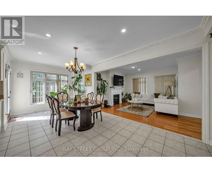 A dining room with a table set for six with a chandelier above it.
