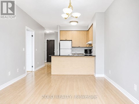 A well-lit kitchen area with wooden floors and a central island.
