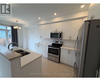 A kitchen with white cabinets and a wooden countertop.