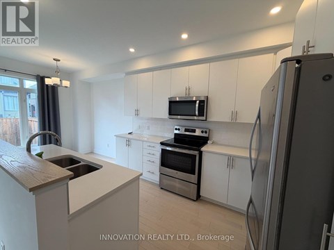A kitchen with white cabinets and a wooden countertop.