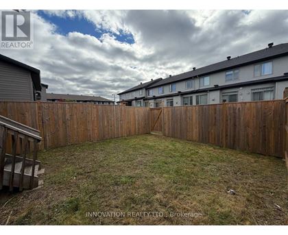 A backyard with a wooden fence and grassy area.