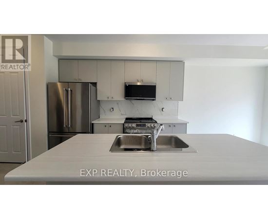 A kitchen with a sink and a refrigerator.