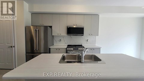 A kitchen with a sink and a refrigerator.