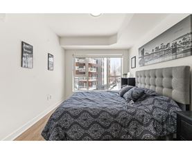 A bedroom with a large bed and a window overlooking a building.