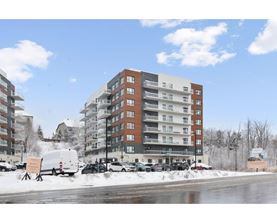 A large apartment building with a parking lot in front of it.