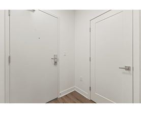 Two white doors with silver handles in a room.