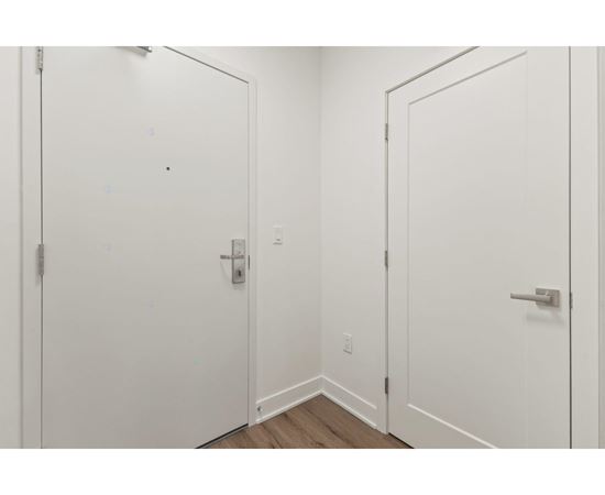 Two white doors with silver handles in a room.