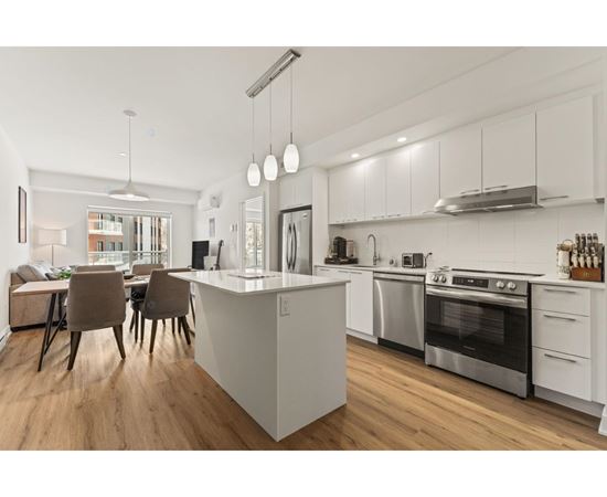 A modern kitchen with a white island and stainless steel appliances.