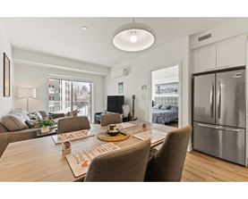 A modern dining room with a wooden table and chairs.