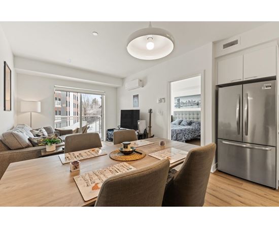 A modern dining room with a wooden table and chairs.