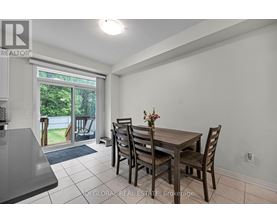 A dining room with a table and chairs and a sliding glass door.