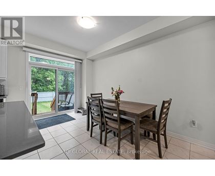 A dining room with a table and chairs and a sliding glass door.