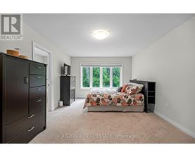 A bedroom with a bed, dresser, and window.