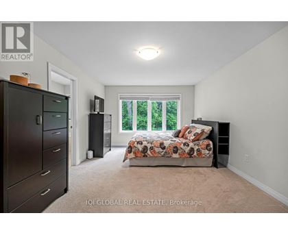 A bedroom with a bed, dresser, and window.