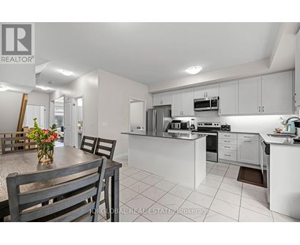 A modern kitchen with white cabinets and appliances.