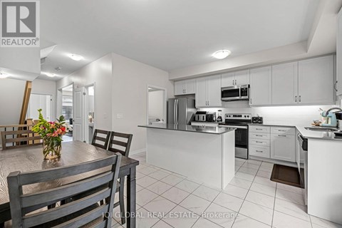 A modern kitchen with white cabinets and appliances.