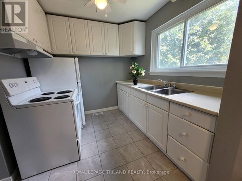 A kitchen with white appliances and cabinets.