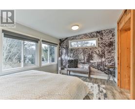 A bedroom with a large bed and a wall mural of a snowy scene.