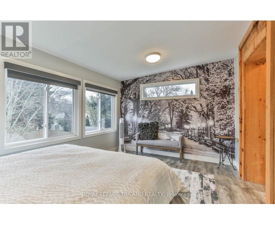 A bedroom with a large bed and a wall mural of a snowy scene.