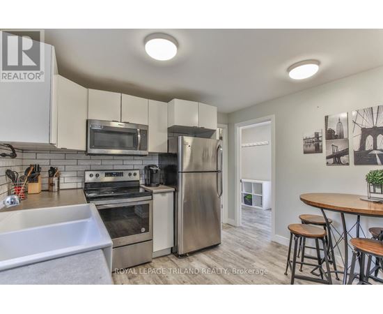 A kitchen with a stainless steel refrigerator and a microwave above the stove.