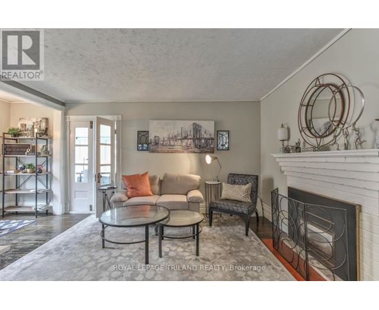 A living room with a fireplace and a painting on the wall.