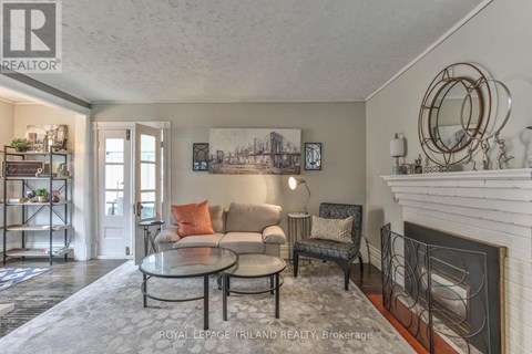 A living room with a fireplace and a painting on the wall.