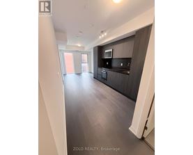 A modern kitchen with dark wood floors and a large island.