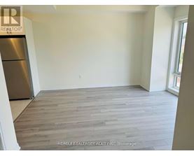 A room with a wooden floor and a refrigerator.