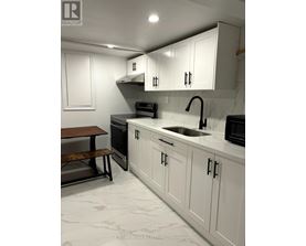 A kitchen with white cabinets and a marble countertop.