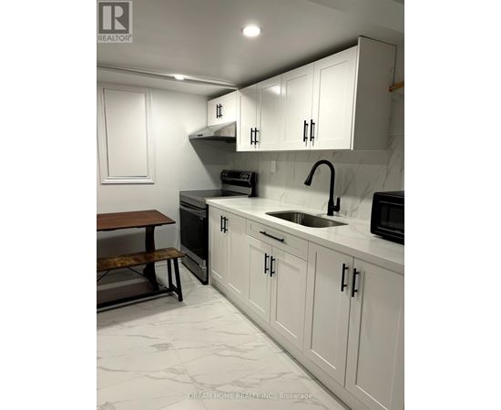 A kitchen with white cabinets and a marble countertop.