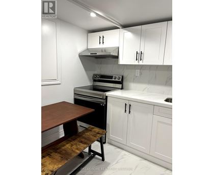 A kitchen with white cabinets and a wooden table.