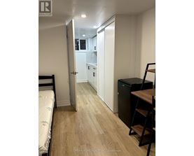A bedroom with a bed, desk, and chair.