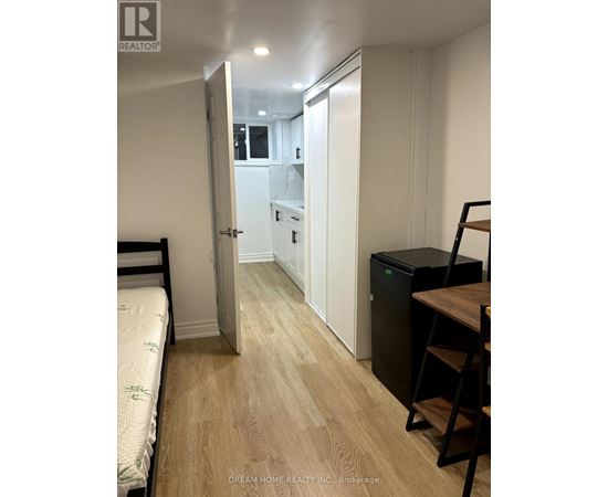 A bedroom with a bed, desk, and chair.