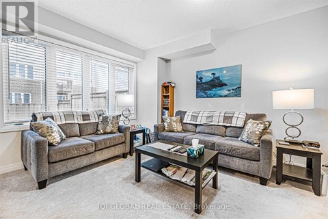 A living room with a grey couch, a coffee table, and a painting on the wall.