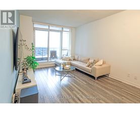 A living room with a couch, coffee table, and a flat screen TV.