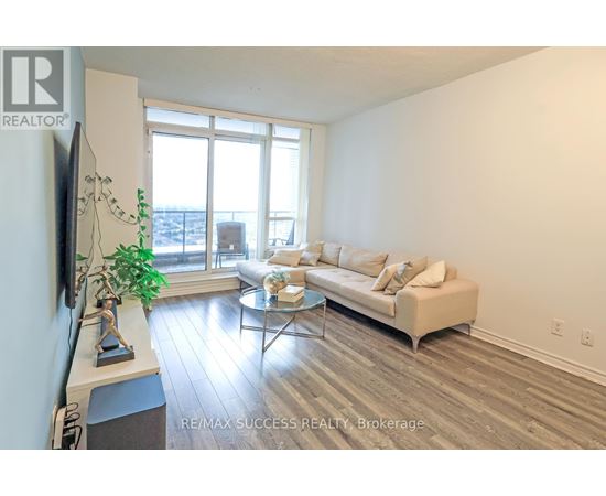 A living room with a couch, coffee table, and a flat screen TV.
