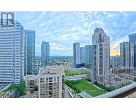 A cityscape with a mix of modern and older buildings, with a clear sky above.