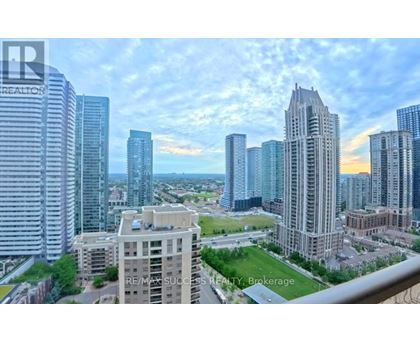 A cityscape with a mix of modern and older buildings, with a clear sky above.