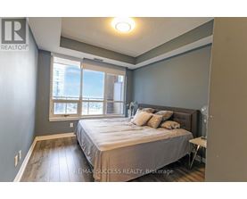 A bedroom with a bed, nightstand, and window.