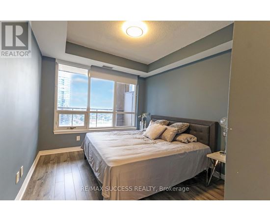 A bedroom with a bed, nightstand, and window.
