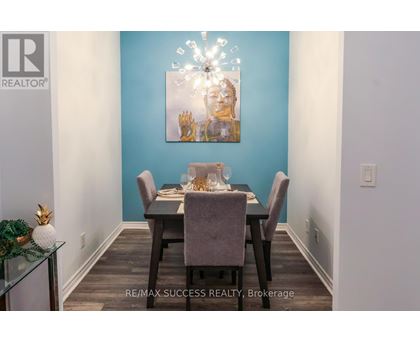 A dining room with a table set for two and a painting on the wall.