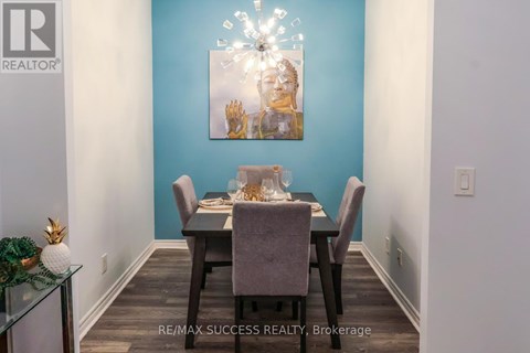 A dining room with a table set for two and a painting on the wall.
