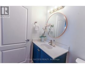 A bathroom with a sink, mirror, and towel.