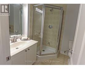 A bathroom with a glass shower door and a white sink.